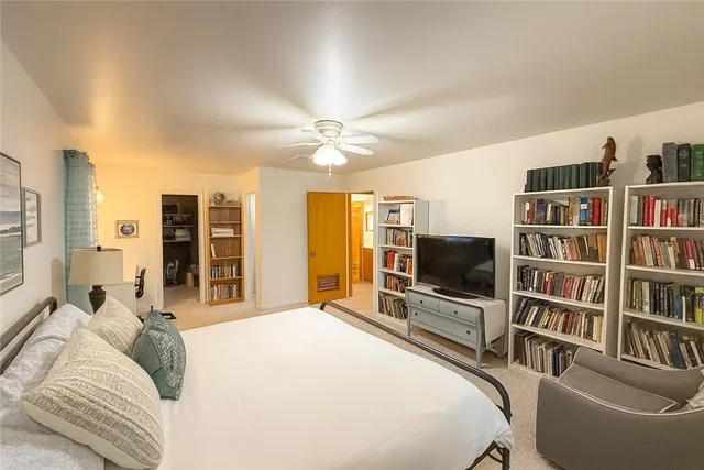 a bedroom with a bed cabinets and a flat screen tv