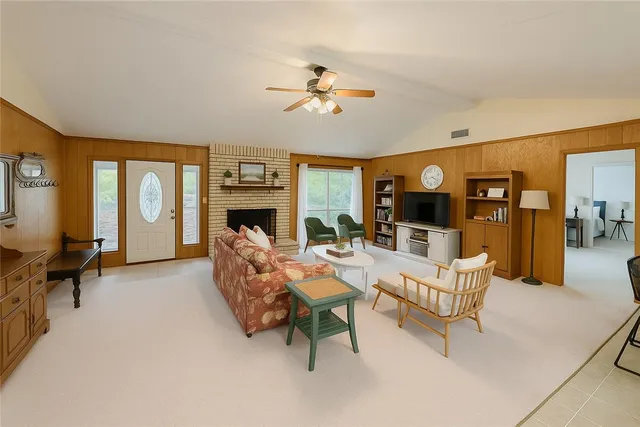 a living room with fireplace furniture and a large window