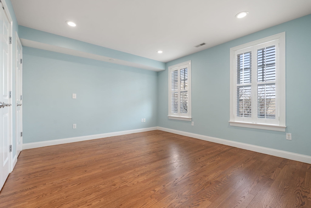 10 Bartlett Street Boston, MA 02129 - Photo 19 of 34 an empty room with wooden floor and windows