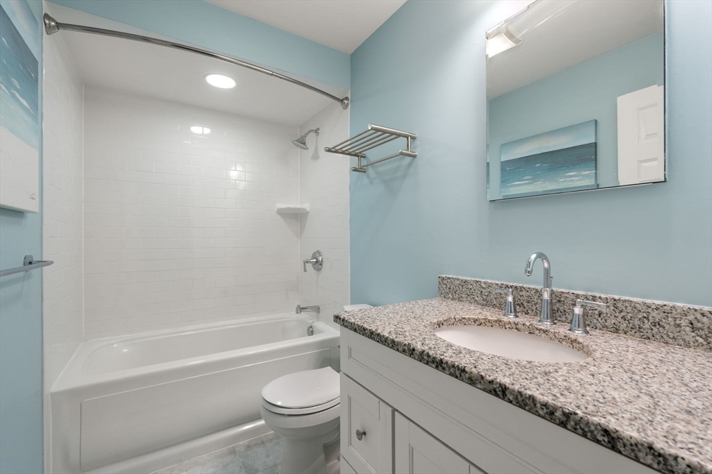 10 Bartlett Street Boston, MA 02129 - Photo 20 of 34 a bathroom with a granite countertop sink a toilet and bathtub