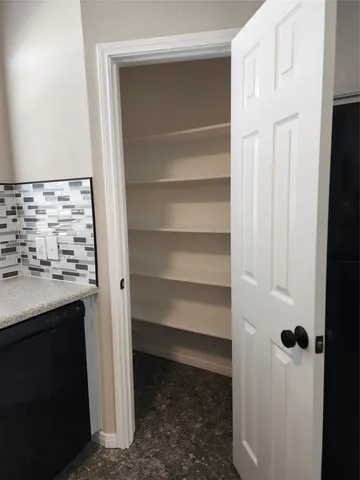 a view of walk in closet with empty racks
