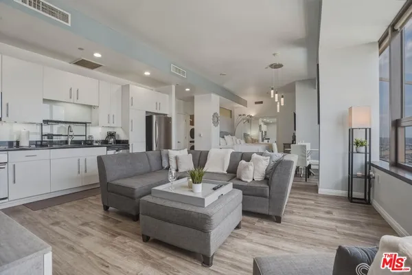 a living room with furniture and kitchen view