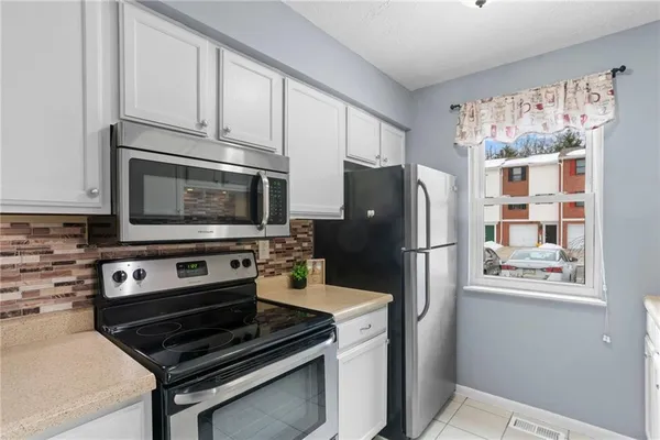 a kitchen with stainless steel appliances a refrigerator a stove a microwave and cabinets