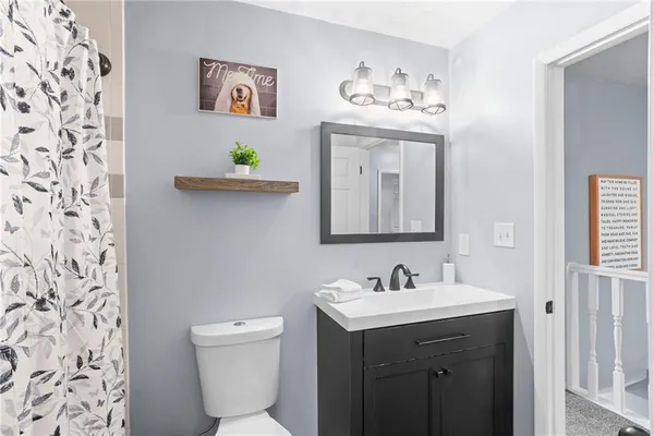 a bathroom with a sink mirror and toilet