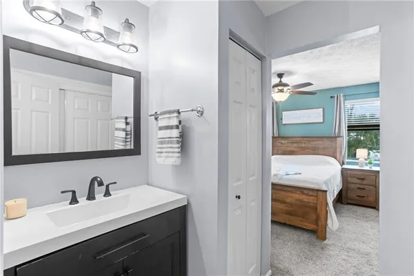 a en suite bathroom with a granite countertop sink and a mirror