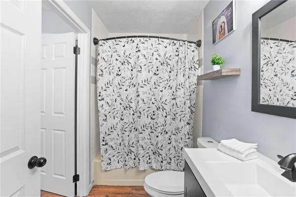 a white toilet sitting next to a shower curtain