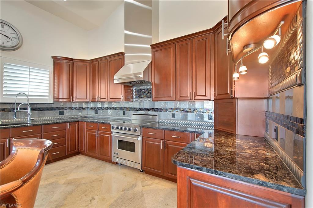 28 West Pelican Street Naples, FL 34113 - Photo 10 of 50 a kitchen with stainless steel appliances granite countertop a sink stove and cabinets
