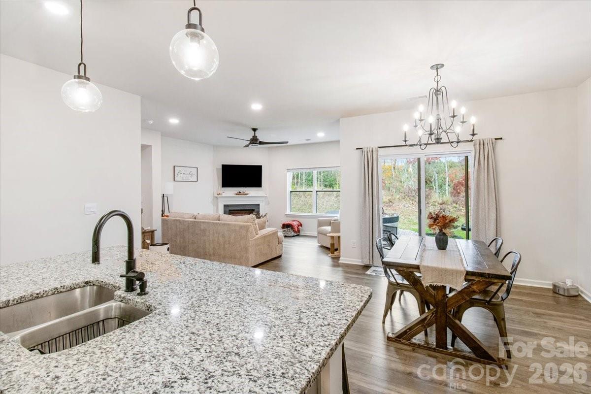 345 Ridgeview Lane Mars Hill, NC 28754 - Photo 4 of 13 a kitchen with stainless steel appliances granite countertop a stove a refrigerator a sink dishwasher a dining table and chairs with wooden floor