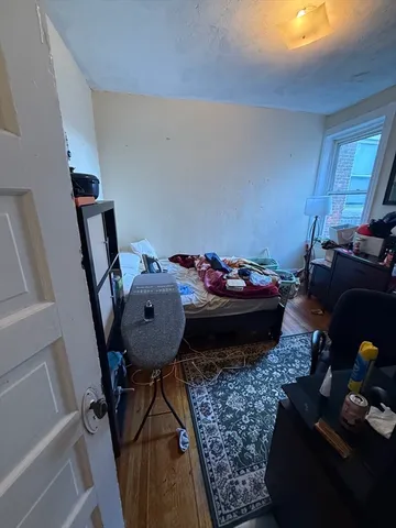 a bed sitting in a bedroom next to a window