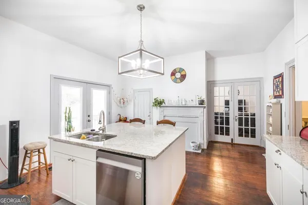 a open kitchen with a sink a center island and wooden floor