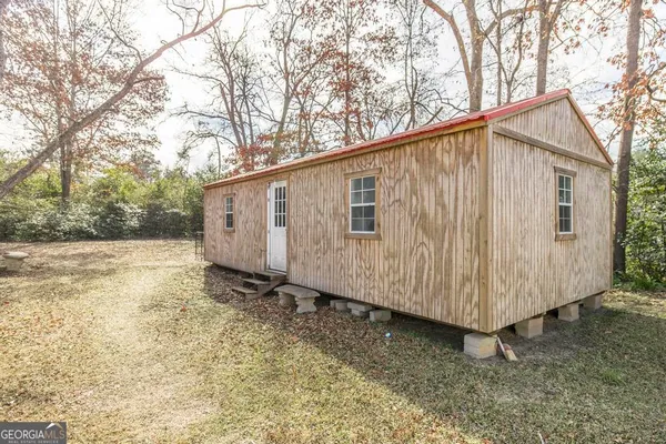 a view of a small house with a yard