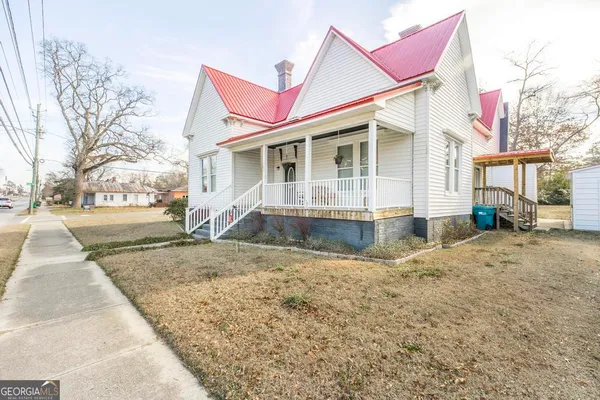 a view of a house with a yard and sitting area