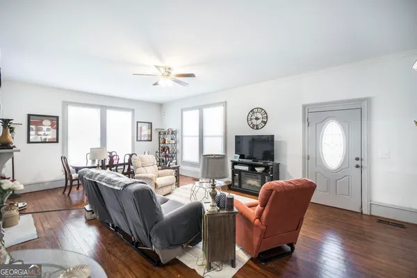 a living room with furniture and a wooden floor