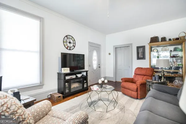 a living room with furniture a flat screen tv and a window