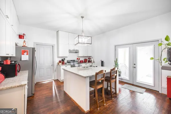 a kitchen with a dining table chairs refrigerator and cabinets