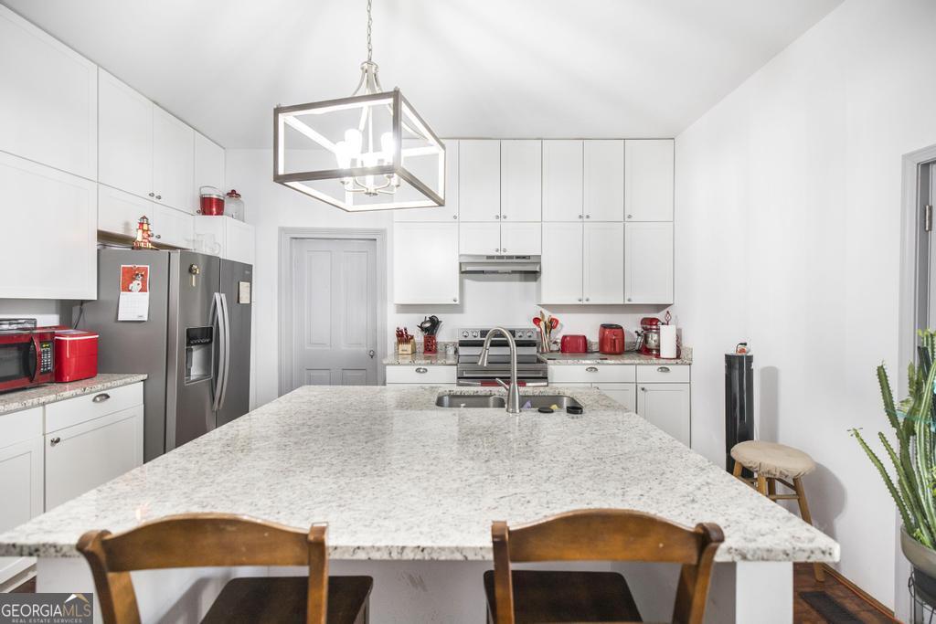 169 West Dykes Street Cochran, GA 31014 - Photo 10 of 34 a very nice looking dining room with kitchen island a stove a table and chairs