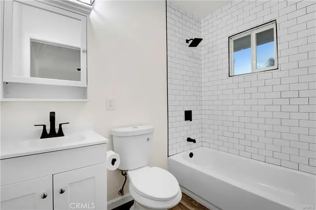 a bathroom with a bathtub shower sink mirror vanity and toilet
