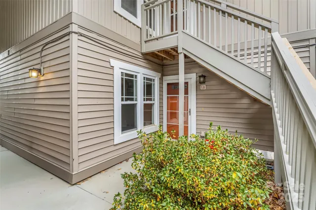 a view of a house with a large window and flower plants