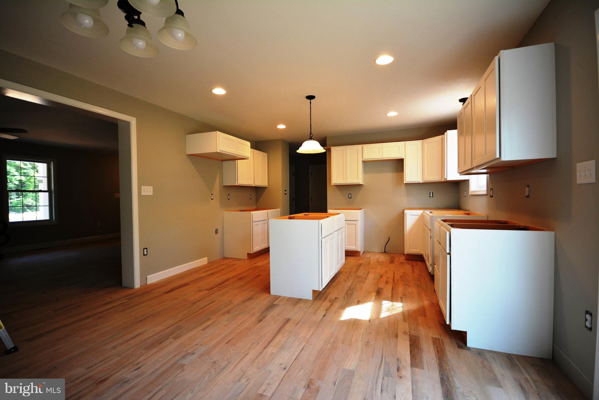 155 Lower View Road Strasburg, VA 22657 - Photo 14 of 30 an open kitchen with kitchen island white cabinets and stainless steel appliances