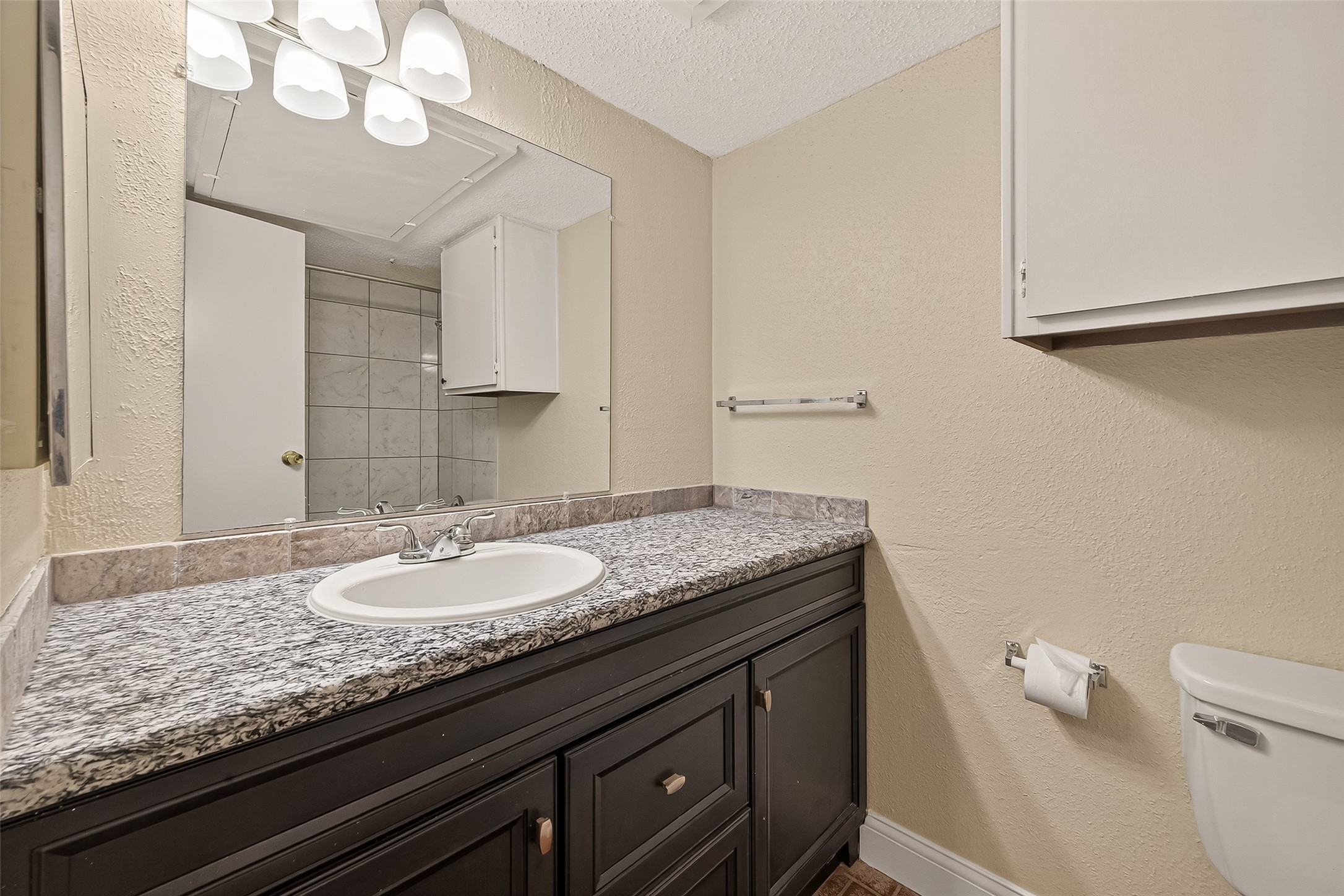 1500 Bay Area Boulevard, Unit 183 Houston, TX 77058 - Photo 12 of 24 a bathroom with a granite countertop sink a toilet and a mirror
