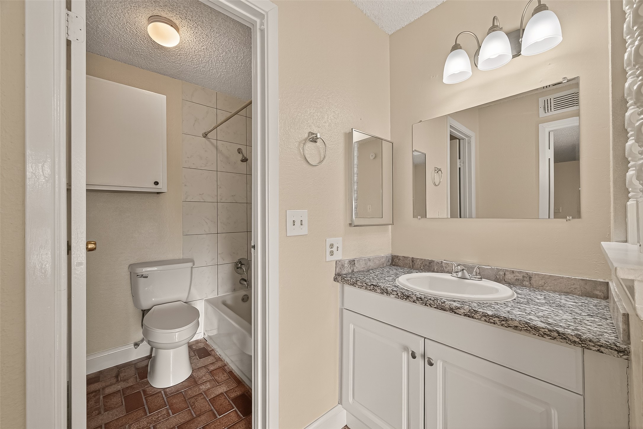 1500 Bay Area Boulevard, Unit 183 Houston, TX 77058 - Photo 15 of 24 a bathroom with a granite countertop sink a toilet and a mirror