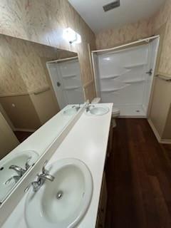 1302 Crescent Street Denton, TX 76201 - Photo 17 of 24 Full bath with dark wood-type flooring, double vanity, a stall shower, and wallpapered walls