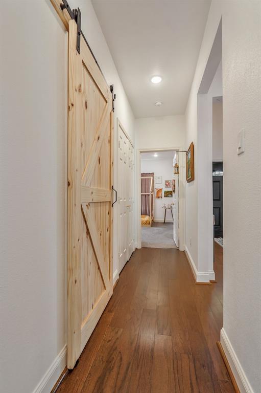 1909 Willowcrest Loop Denton, TX 76205 - Photo 23 of 40 Hall between guest bdrms with 2 closets a barn door to bath and dark wood-type flooring