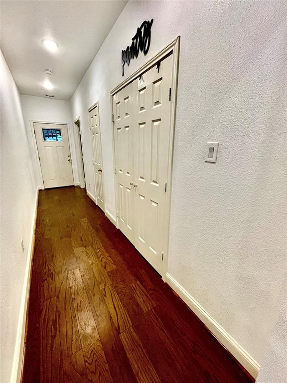 1909 Willowcrest Loop Denton, TX 76205 - Photo 29 of 40 Hall to garage with large oversized pantry and storage closet, featuring dark wood finished floors and a textured wall