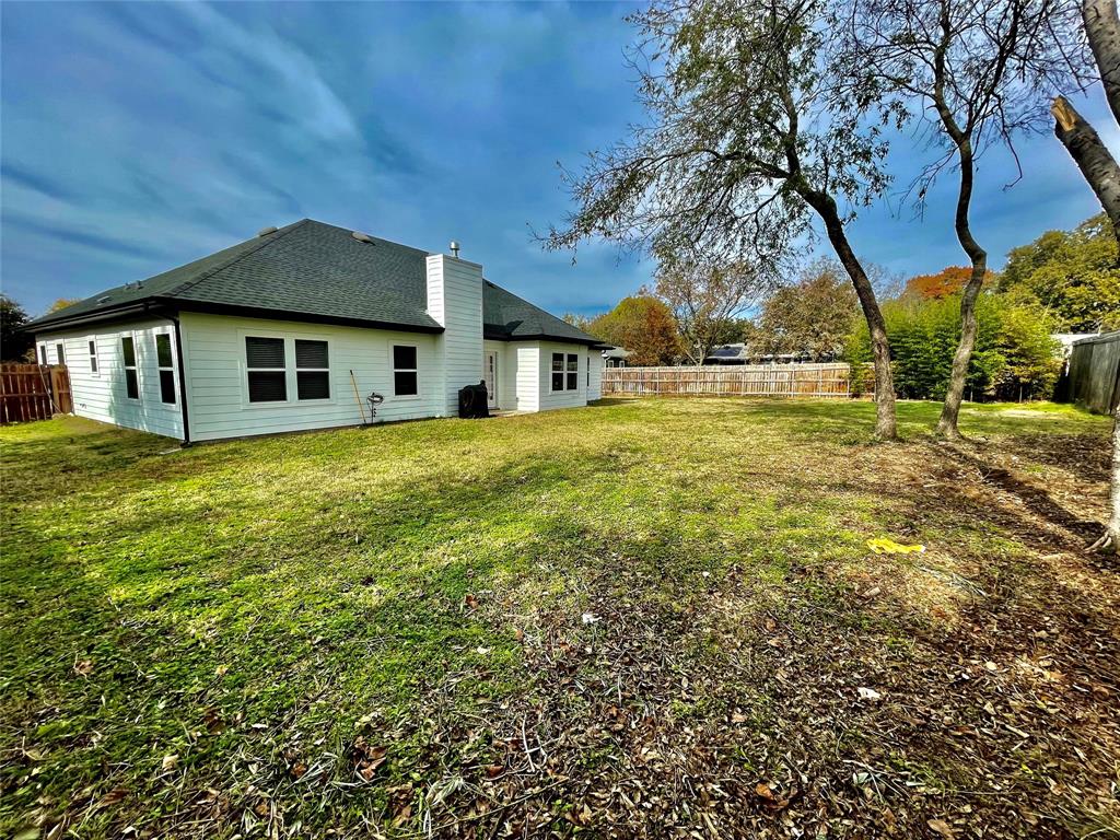 1909 Willowcrest Loop Denton, TX 76205 - Photo 34 of 40 Rear view of property with a fenced backyard, a chimney, and roof with shingles