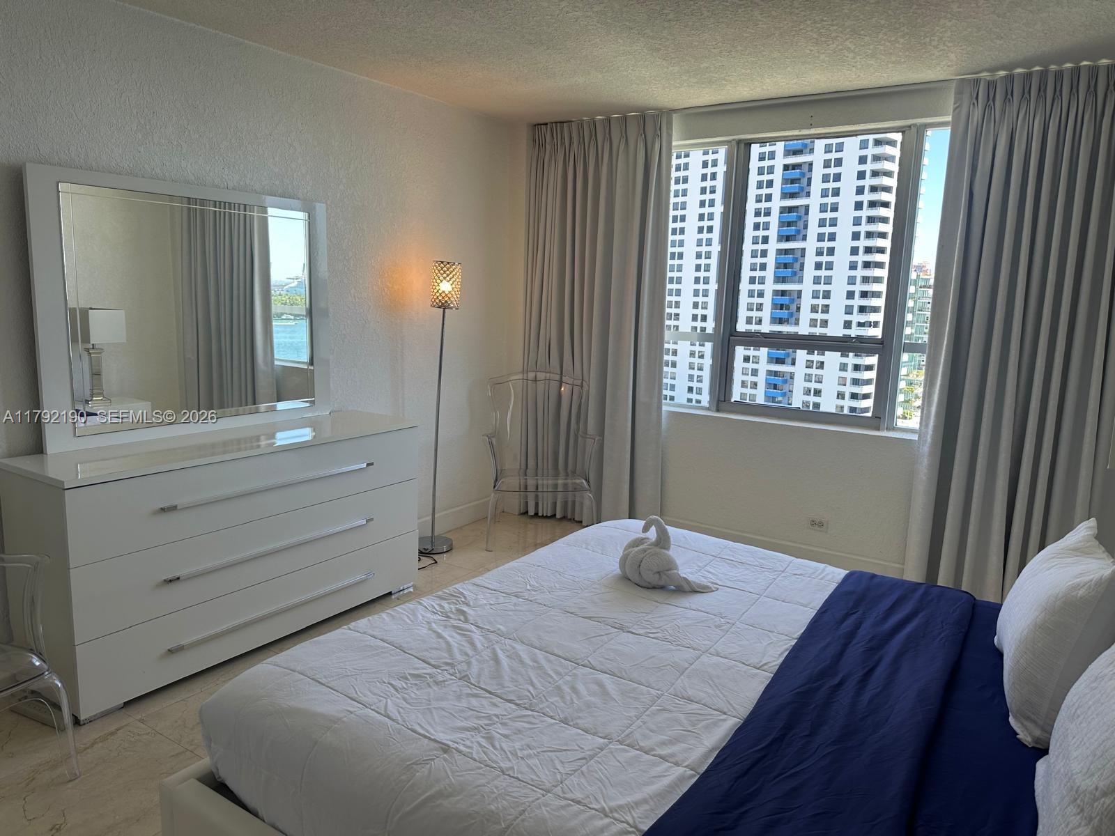 1500 Bay Road, Unit 1528S Miami Beach, FL 33139 - Photo 16 of 29 a bedroom with a bed and a dresser