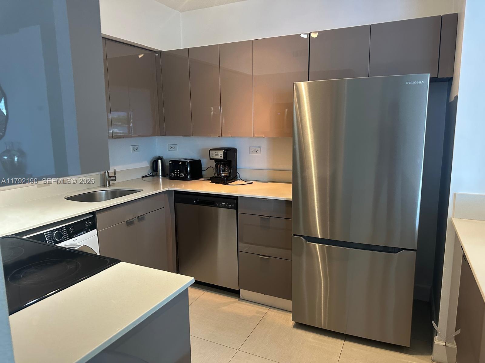 1500 Bay Road, Unit 1528S Miami Beach, FL 33139 - Photo 9 of 29 a kitchen with a refrigerator and a sink