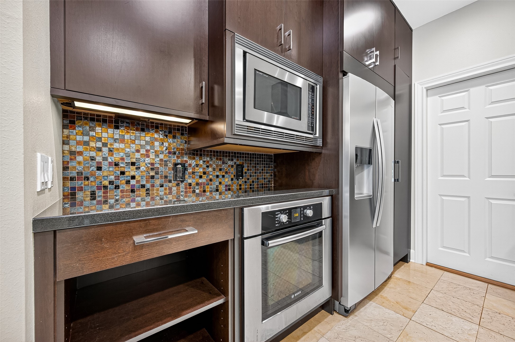 3027 Bissonnet Street Houston, TX 77005 - Photo 16 of 47 Tile backsplash, stainless range, and dark cabinetry — a kitchen worth spending time in