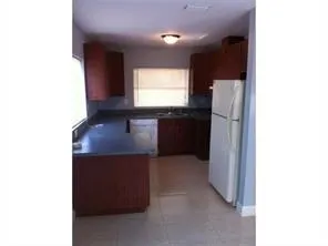 a kitchen with kitchen island sink and refrigerator