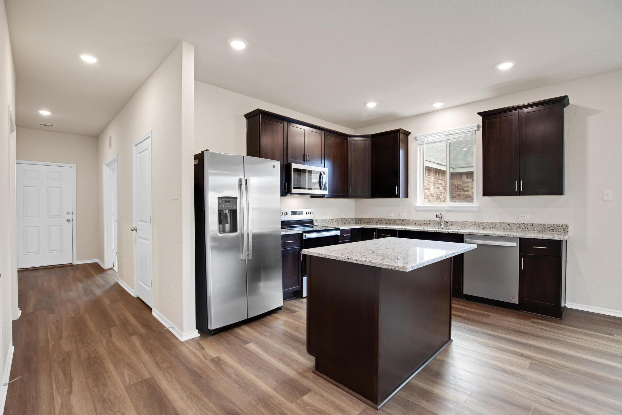 200 Janice Road Taylor, TX 76574 - Photo 8 of 25 A contemporary kitchen space boasts rich cabinetry and an inviting island with ample counter space.