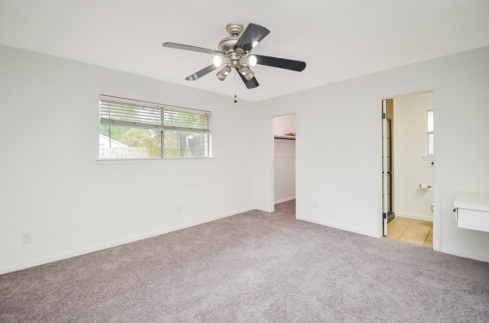 9014 Langfield Road Houston, TX 77040 - Photo 19 of 37 Plush, soft carpet underfoot paired with a modern ceiling fan and light fixture.