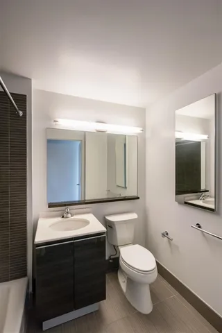 a bathroom with a sink a toilet and mirror