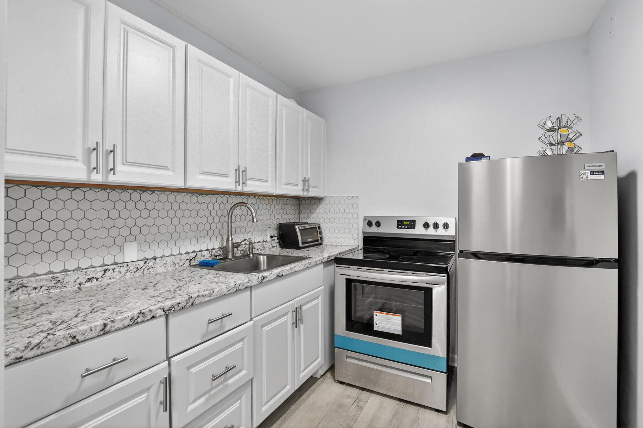 485 Mansfield K Boca Raton, FL 33434 - Photo 12 of 73 a kitchen with granite countertop a refrigerator sink stove and cabinets