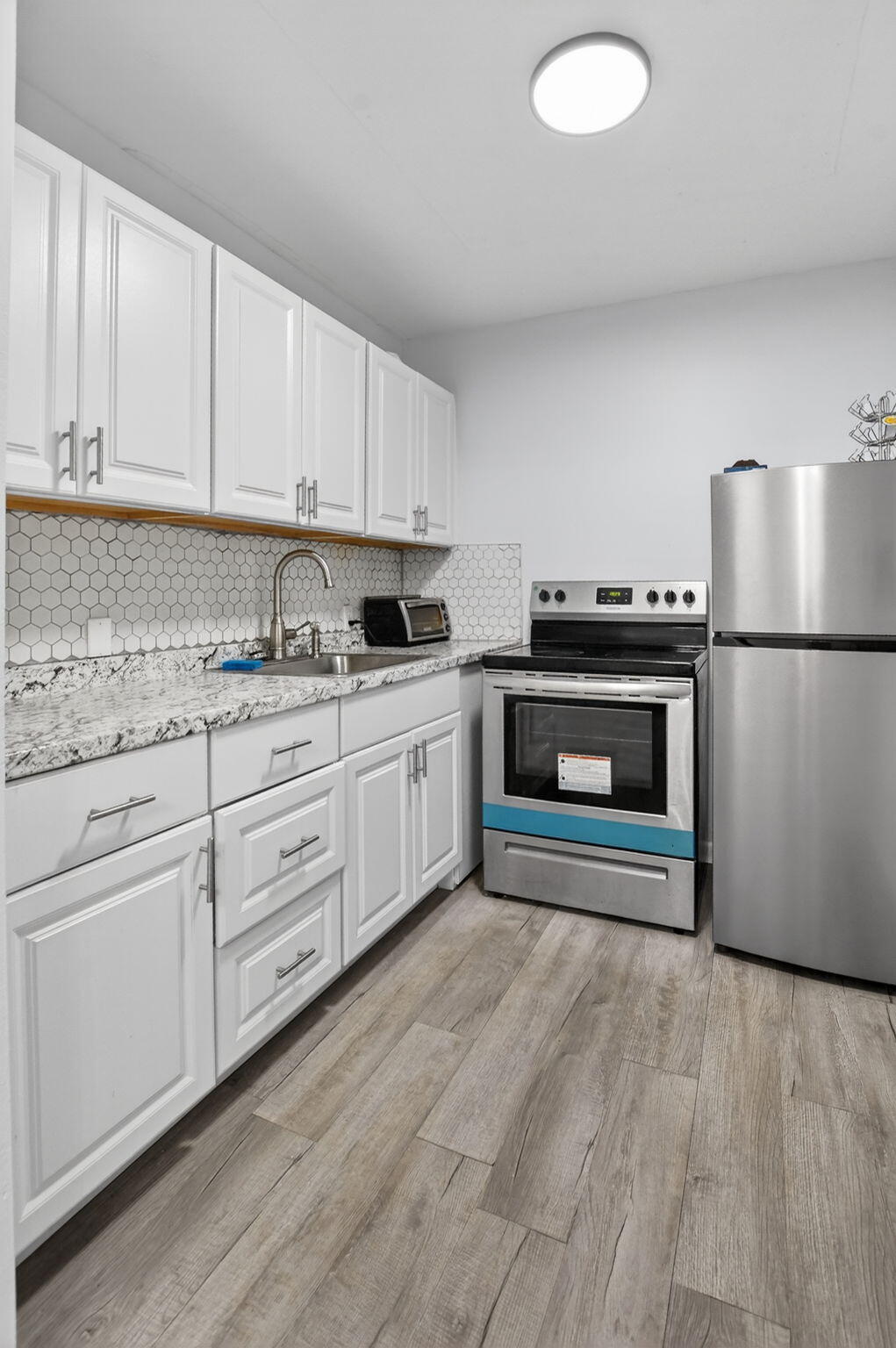 485 Mansfield K Boca Raton, FL 33434 - Photo 13 of 73 a kitchen with stainless steel appliances granite countertop a stove a sink and white cabinets