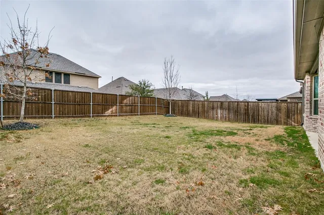 a view of a yard with wooden fence