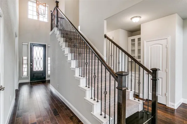 a view of staircase with wooden floor and white walls