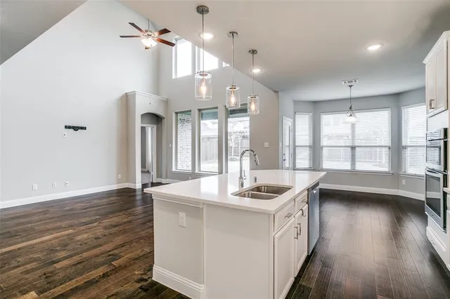a kitchen that has a sink a stove and wooden floor