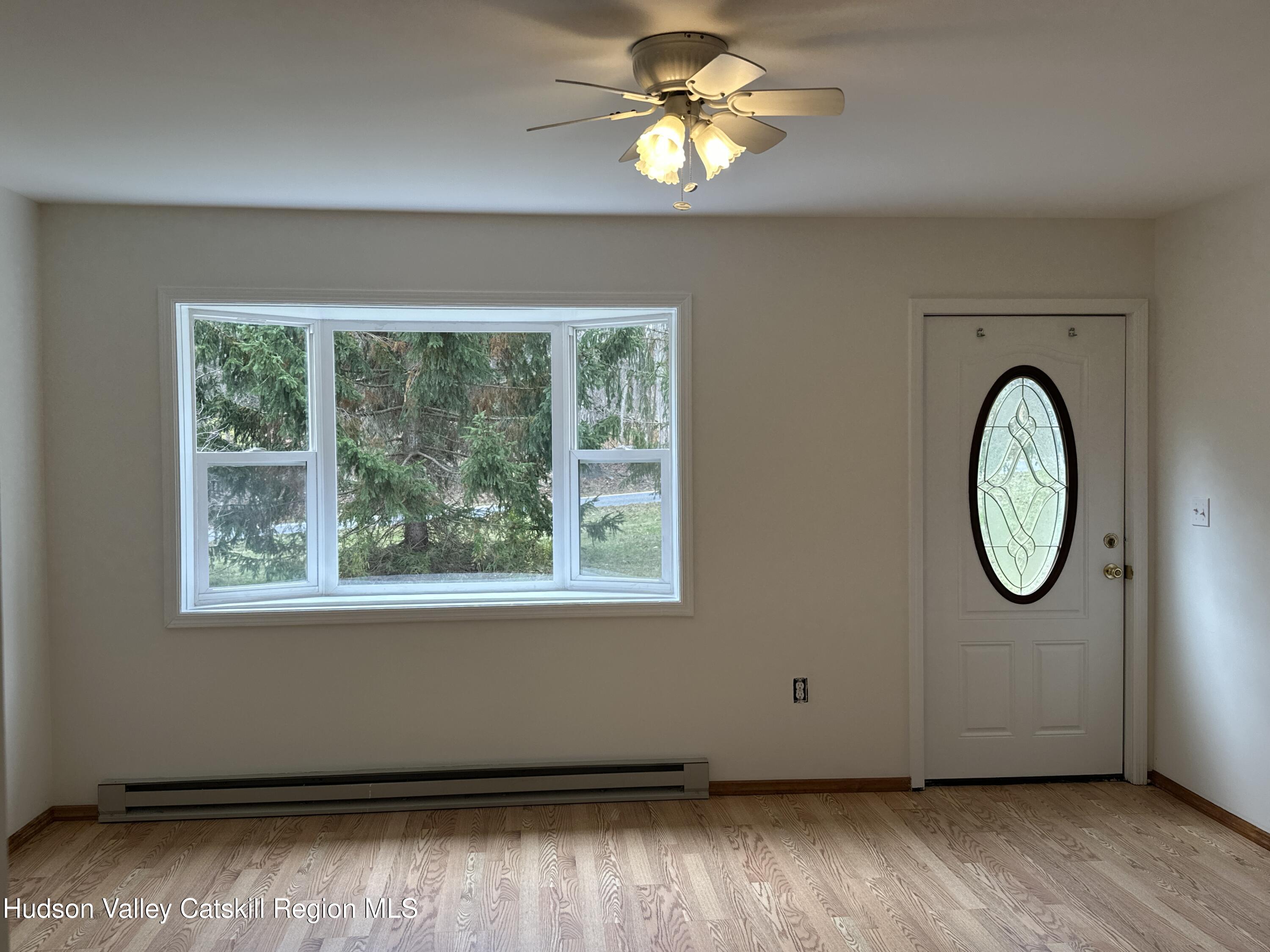 470 Edison Timmerman Road Cairo, NY 12413 - Photo 7 of 29 an empty room with wooden floor fan and window