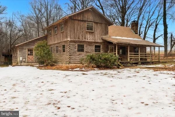 a front view of a house with a yard covered with snow