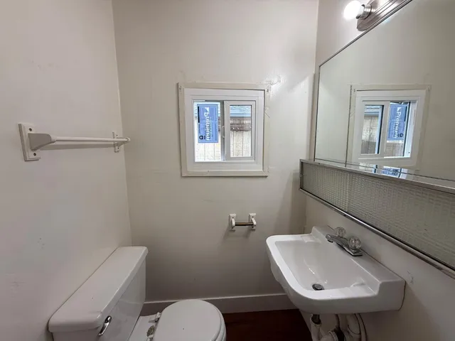 a bathroom with a toilet sink and mirror