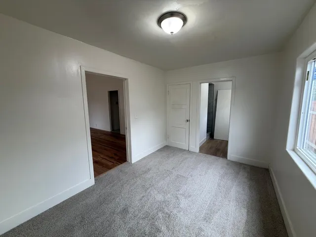 an empty room with windows and closet