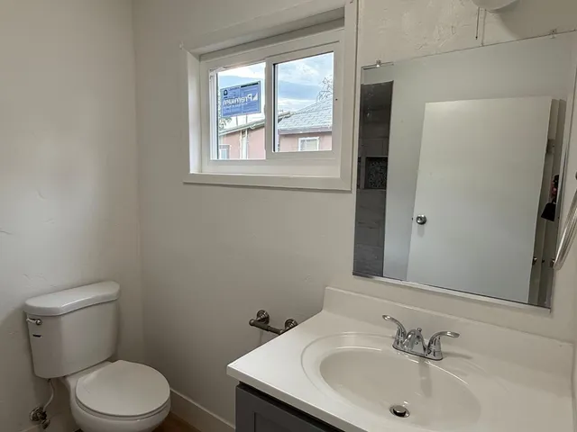 a bathroom with a sink a toilet and a mirror
