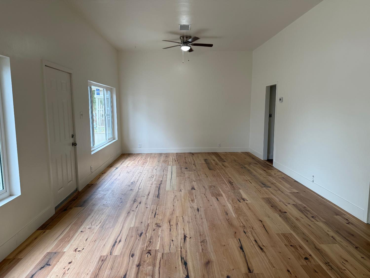 548 East Pleasant Street Coalinga, CA 93210 - Photo 7 of 18 wooden floor in an empty room with a window