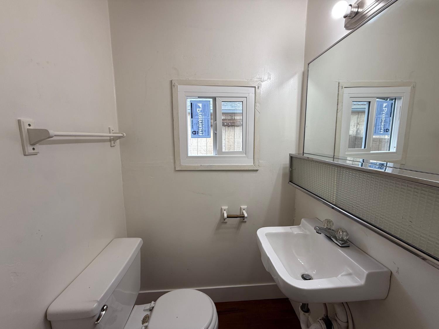 548 East Pleasant Street Coalinga, CA 93210 - Photo 8 of 18 a bathroom with a toilet sink and mirror