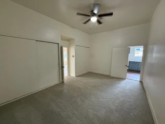 an empty room with closet and windows