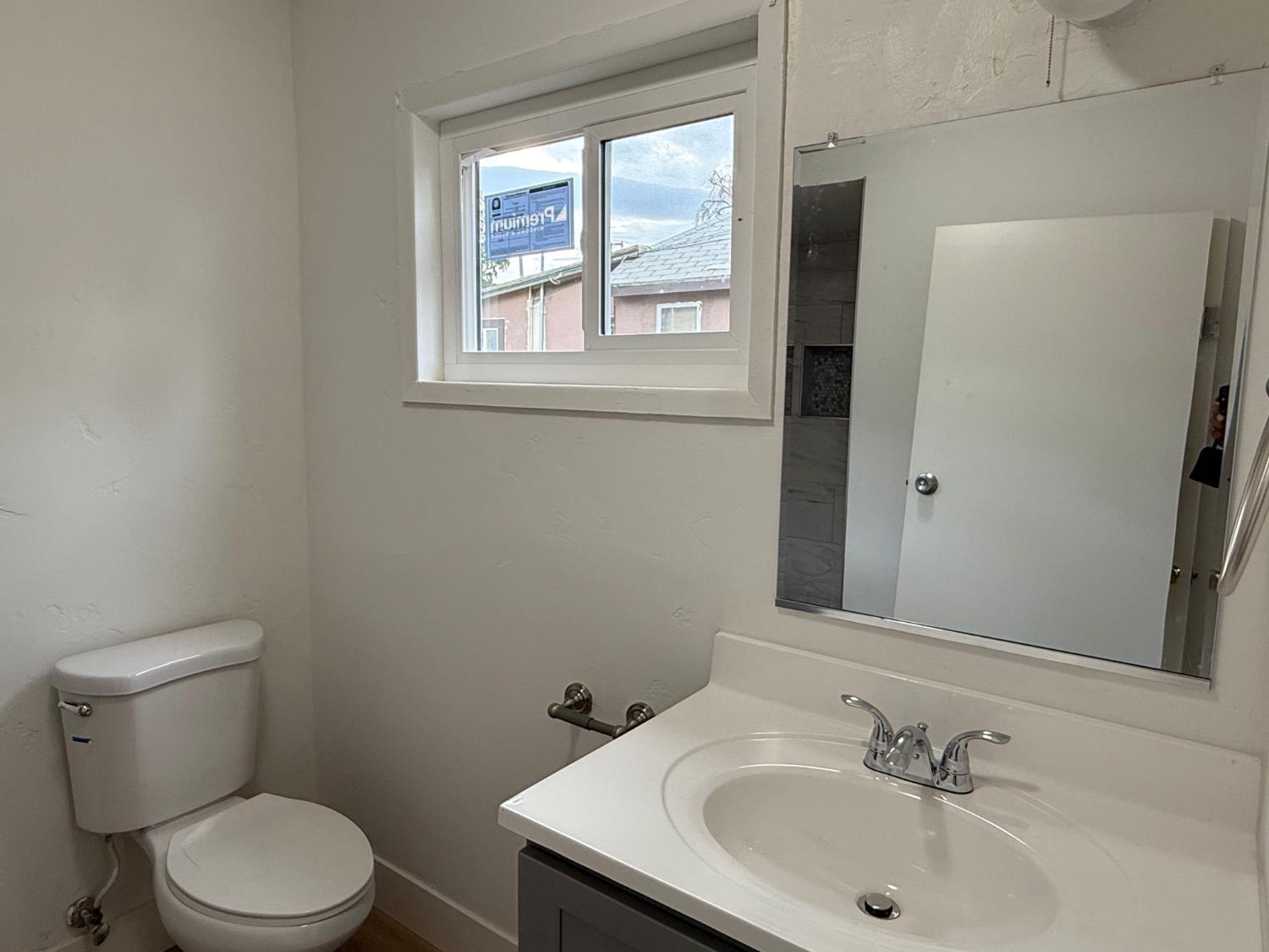 548 East Pleasant Street Coalinga, CA 93210 - Photo 10 of 18 a bathroom with a sink a toilet and a mirror